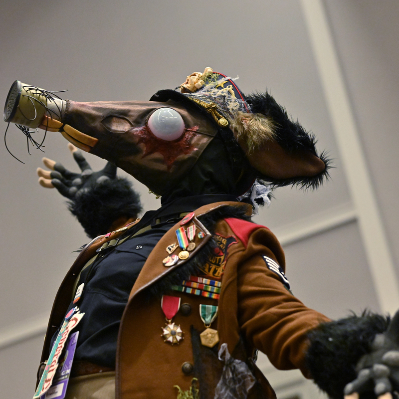 A person wearing military costume and a long gas mask resembling a rat's face with large eyes, teeth, and whiskers. Link takes you to project page.