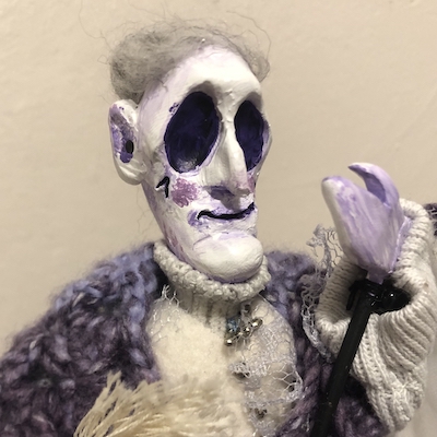 A cartoonishly sculpted ghost puppet of a grandmother, dressed in a shawl and lace blouse with brooches. Picture links to project page.