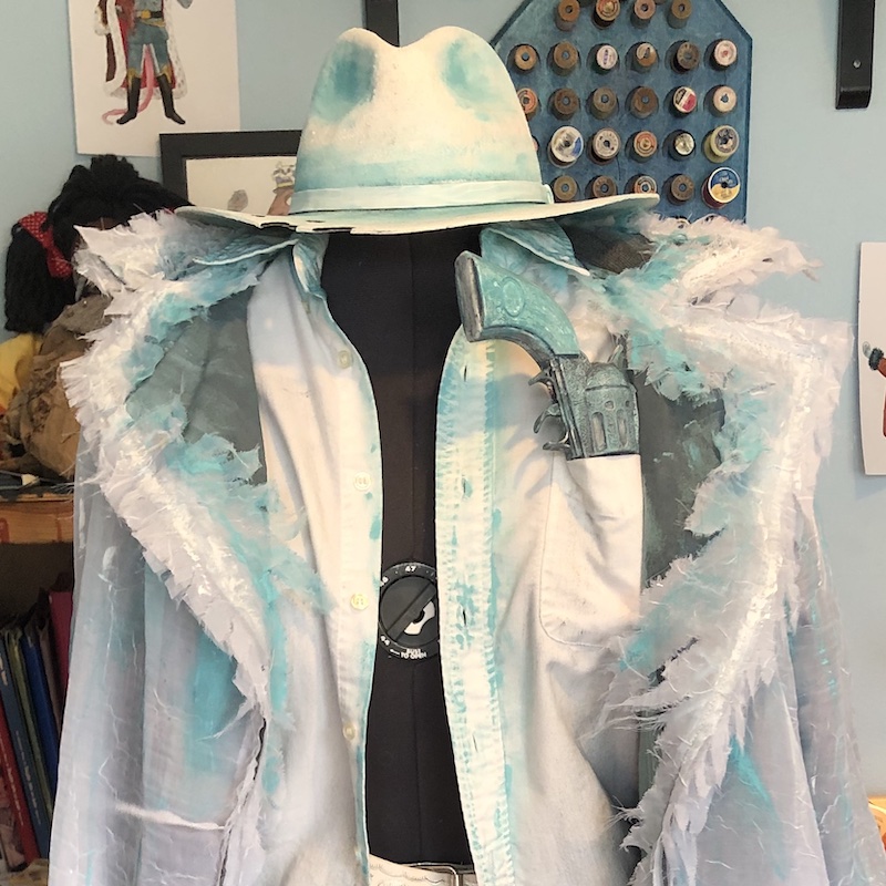 A close-up photo of a grey coat and wide-brimmed hat on a dress form. Link takes you to project page.